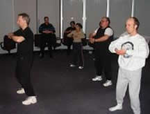 The Collaborative Group, Ltd., Stony Brook (February 2004): Laoshi Laurince McElroy leading Collaborative Group colleagues in a Tai Chi Qigong Stretch during a WARRIOR WELLNESS session. 