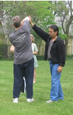 Tai Chi Sundays (May 2005): Laoshi Laurince McElroy and Paul Adago, Jr., demonstrate the importance of keeping your elbows dropped to the group at The Common Ground in Sayville.