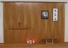 In the Kwoon: The studio shrine at 29 South Ocean, renovated in July 2005 by Deb Monteleone of Suffolk Aikikai, is a mixture of two arts. Water Tiger School's shrine (just above floor level) includes Master Yang Chein-Hou's portrait, two candles, a tiger figurine, and a Chinese pouch. Suffolk Aikikai's shrine includes Master Ueshiba's portrait and Japanese calligraphy (hanging R), tea cups and Master Ueshiba's statue (on the shelf), and a sword stand (just above floor level).