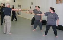 In the Kwoon, ABC T'ai Chi with Spencer Gee (October 2005): Guro Robert Mulligan (far L), from Kwikstik Martial Arts, teaching basic Pananandata stick techniques to the "Gray Shirts" attending the Weapons Application seminar in the studio  (from L to R in the WTS shirts, Laoshi Laurince McElroy, Joel Valario, and April Alexander.