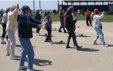 World Tai Chi & Qigong Day; Shorefront Park, Patchogue NY (April 24, 2004): Spencer Gee (toward Right wearing red), from the Spencer Gee Wellness Corp in Old Westbury, leads a workshop on his "T'ai Chi Workout."