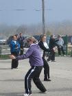 World Tai Chi & Qigong Day; Shorefront Park, Patchogue NY (April 25, 2009): For the third year, the facilitators on hand at 10A came together for a group demonstration during the break. As it has for the past two years, the demo successfully captured the separate unison, the varied similarity, the mixed harmony that are the arts of T'ai Chi and Qigong. Playing different aspects from their lineages (L to R) are Spencer Gee, Spencer Gee Wellness Corporation of Old Westbury; Mike Dalia, associate of Nancy Fiano; Sharon Infante, Music, Movement and More of Mt. Sinai; Judith Budd-Walsh, Harmonious Movement of Hauppauge; and Nancy Fiano, Dojo of the Dancing Dragon of Lindenhurst. Laoshi McElroy, Water Tiger School of Patchogue, is not pictured.