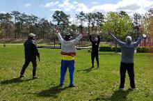 World Tai Chi & Qigong Day; Diamond in the Pines, Coram NY (April 27, 2019): Beginning his workshop, "An In-Depth Look into a Variety of the Tai Chi Forms Movements", Elan Abneri (Facing), a senior student of Tyrone Wei Wicksman at Silent Fist Tai Chi in Huntington Station, leads participants in a series of warm-up exercises.