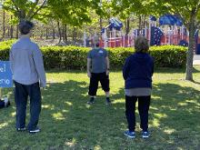 A male faciliator talks to a small number of participants about the Qigong set they are about to explore.
