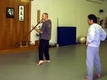 In the Kwoon, Introduction to Tai Chi Staff (December 2007): With Si-Suk Paul Adago, Jr., watching intently, Laoshi Laurince McElroy demonstrates and discusses a detail of Shaking Mountain & Pushing Sea from the Traditional Yang-Style Staff Form.