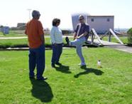 Tai Chi in the Park (May 5, 2007): Without the necessary chairs, Laoshi Laurince McElroy explains a seated knee stretch to Uma & Ven Murthy.