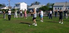 Tai Chi in the Park (September 1, 2007): Nancy Fiano (second from the Left in white), Dojo of the Dancing Dragon in Lindenhurst, leads an exercise in coiling, spiraling, and body awareness.