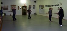 In the Kwoon, Introduction to Tai Chi Straight Sword (February 2008): To foster familiarity with the straight sword during the first repeat of the seminar series that began in January 2007, the group follows McElroy Laoshi (L) in a walking exercise of Right / Left Interception.