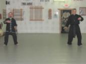 In the Kwoon, Si-Suk Joel Valerios Ascension Ceremony (August 23, 2011): During the demonstrations, the soon-to-be Laoshi (L) plays a mirror-image version of Water Tiger's Medium-Frame Yang-Style 24-Posture Form to current Laoshi Laurince McElroy's regular version.