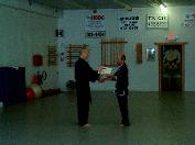 In the Kwoon, Si-Suk Joel Valerios Ascension Ceremony (August 23, 2011): Laoshi Laurince McElroy (L) presents Laoshi Joel Valerio his certificate, which he described as " ... a pretty piece of paper, with nice words, in a simple frame."