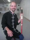 In the Kwoon, Si-Suk Joel Valerios Ascension Ceremony (August 23, 2011):      Newly minted Laoshi Joel Valerio poses with his gift from Laoshi Laurince McElroy  a symbolic token of himself  McElroy Laoshis first lions head practice sword.