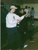 World T'ai Chi & Qigong Day; South Ocean Middle School Gymnasium, Patchogue NY (April 6, 2002): Using some unorthodox "props" in the gym at South Ocean Middle School, Spencer Gee works with a participate on balance, alignment, strength, and focus.
