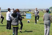 World Tai Chi & Qigong Day; Shorefront Park, Patchogue NY (May 3, 2014): Laoshi Laurince McElroy (facing) from Patchogues Water Tiger School of Tai Chi Chuan warms participants up for his Setting the Foundation: Lower Body Blaster workshop. Photo by Joe Cavaliere, taichi-daily.com.