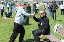 World Tai Chi & Qigong Day; Shorefront Park, Patchogue NY (May 3, 2014): Using a bench to help demonstrate the importance of relaxed structure, Elan Abneri (R), a senior student of Sifu Tyrone Wei Wicksman at Zhang Style Tai Chi Chuan in Centereach, leads his workshop focusing on an in-depth exploration of hip alignment with attention on the rear leg. Photo by Joe Cavaliere, taichi-daily.com.