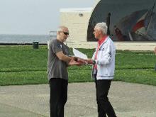 World Tai Chi & Qigong Day; Shorefront Park, Patchogue NY (April 29, 2017):  Joseph E. Keyes Jr., Village of Patchogue Commissioner of Parks & Recreation and Trustee (R) presents Event Coordinator Laurince McElroy, of Water Tiger School of Tai Chi Chuan in Medford (L), with a Proclamation from the Honorable Paul V. Pontieri, Jr., Mayor of Patchogue, and the Village Board of Trustees. In his remarks, Mr. Keyes recognized the 17-year history of the event in the Village of Patchogue and acknowledged McElroy Laoshis earlier mention of the world-wide Peoples Climate March. 