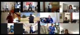 Screenshot image of a Zoom session in gallery view. 12 people, some standing and some seated, with one arm and hand, palm up, extending forward on its side of the body and with the other arm and hand, palm up, being held at the waist.