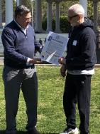 A political dignitary presenting a proclamation to the event coordinator.