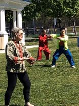 A woman and two men playing empty-hand T'ai Chi forms from three different lineages.