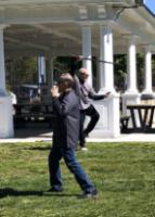 Two men, who are facing different directions, playing different T'ai Chi forms - one, an empty-hand form, and one, a Chinese straight sword form. 