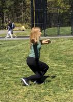 A woman, in a low cross-stepping stance, playing an empty-hand T'ai Chi form.