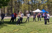 A female facilitator leads a group of participants through a particular moment in an empty-hand T'ai Chi form. 